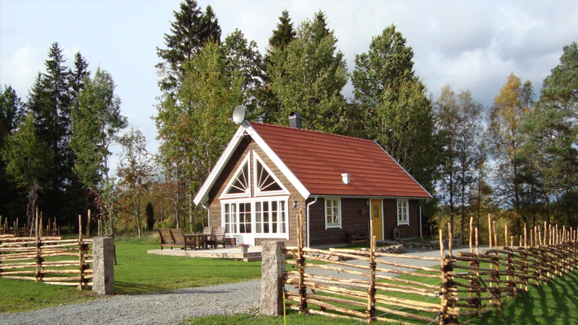 Timrad stuga omgärdad med gärdesgård.